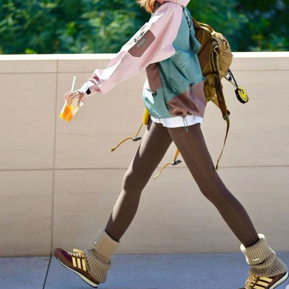 Woman walking outdoors in high-waisted leggings with a backpack